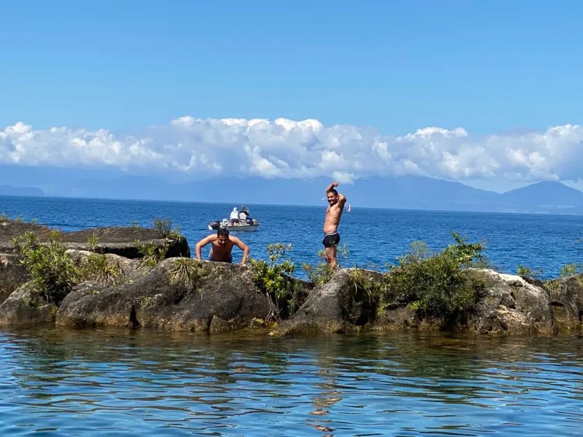 things to do in Taupo with kids- 2 guys swimming and relaxing in lake